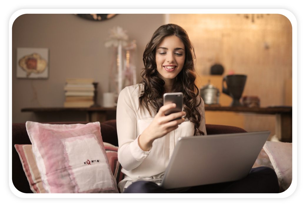 Girl Sitting on Bed Using Laptop And Smartphone